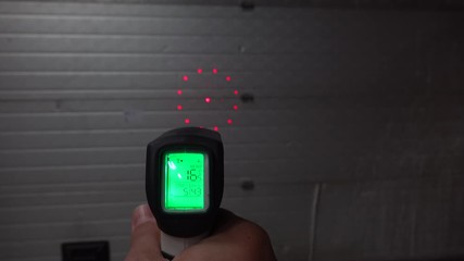 Infrared thermometer checking heat leaks at the warehouse.