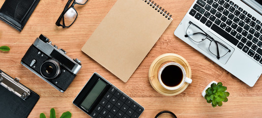 Brown office table with laptop, calculator and camera. Top view. Free space for your text. Flat lay.