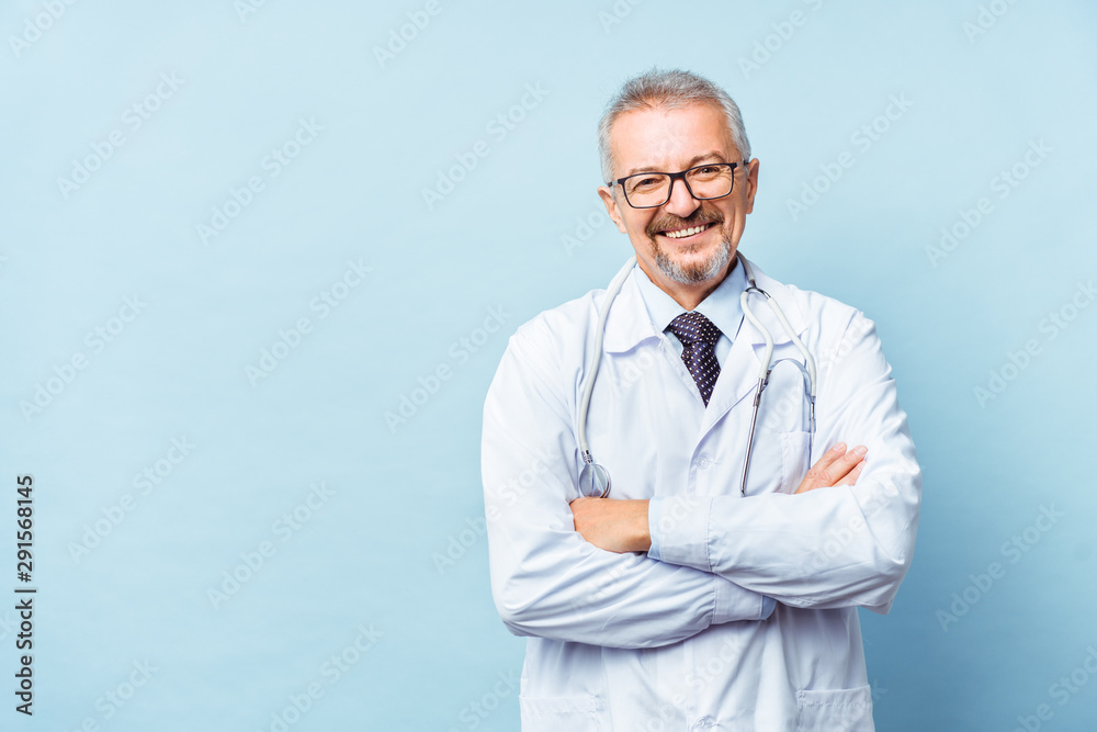 Wall mural Cheerful mature doctor posing and smiling at camera, healthcare and medicine.