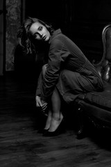 Alluring young woman sitting on a vintage sofa