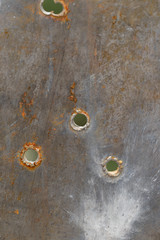 Metal texture with bullet holes. Close-up.