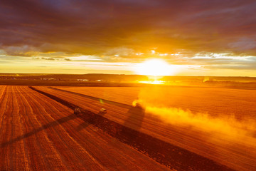 Combine harvester harvests wheat in the field at sunset in autumn in Russia. view from a height of...