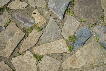 Background of stone-paved uneven track. Construction. Pieces of stone. Handwork.