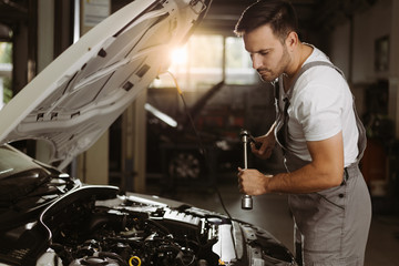 Auto mechanic working with socket wrench in a workshop