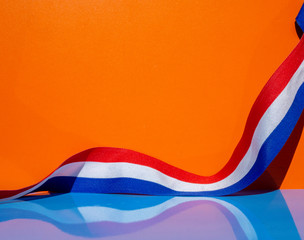 Dutch ribbon in red, white and blue for Kings Day and orange events. - obrazy, fototapety, plakaty