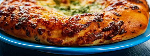Bread with garlic and cheese on a dark wooden background. Photographed close-up.