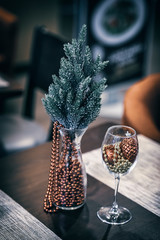 Christmas composition, winter holiday. Fresh coniferous branches of spruce and golden balls and golden garland in wineglass close-up. Vintage background