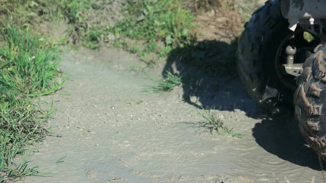Quad bike driver drifts in the mud. Wheels of quad bike drifting in the mud. Quad biking fun.