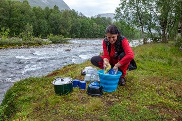 Attraktive Frau bewältigt den Abwasch in der Wildnis