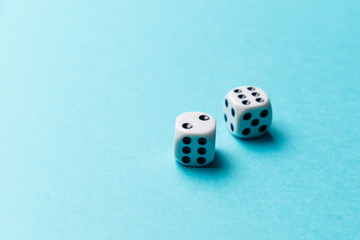White gaming dice on blue background. Top view. Flat lay. Copy space. Game of chance concept. Close-up. Pastel colors