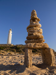 Stack of stones in balance on the beach of Trafalgar Lighthouse. Cádiz, Andalusia. Spain