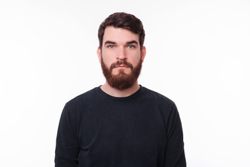 Fototapeta premium Portret poważnego młodzieńca z brodą, patrząc w kamerę