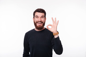 Naklejka premium Cheerful and happy man showing OK gesture