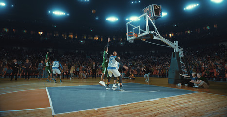 Basketball players on big professional arena during the game. Tense moment of the game. Celebration