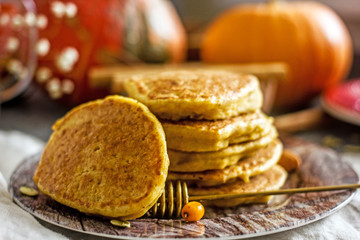 Homemade pancakes stacked on a red plate. Healthy pancakes made with coconut milk and banana, decorated with nuts and fresh berries. Sweet Homemade Stack of Pancakes with Syrup for Breakfast