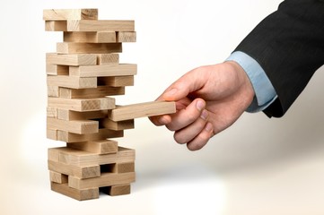 Businessman and wooden tower on blurred background