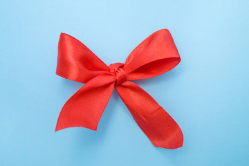 Christmas bow red color on blue background - holidays, celebration concept