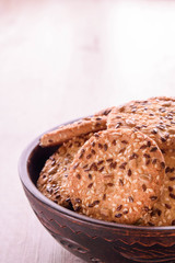 Cookies of sesame seeds, sunflower seeds and other spices on a wooden plate. Bright key