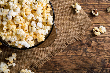 Air salty popcorn.A bowl of popcorn on a wooden table.Salt popcorn on the wooden background .  With space for text.Top view.popcorn texture.Chees .