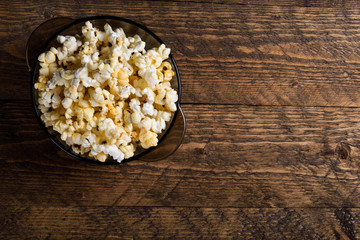 Air salty popcorn.A bowl of popcorn on a wooden table.Salt popcorn on the wooden background .  With space for text.Top view.popcorn texture.Chees .