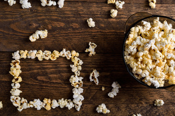 Air salty popcorn.A bowl of popcorn on a wooden table.Salt popcorn on the wooden background .  With space for text.Top view.popcorn texture.Chees .