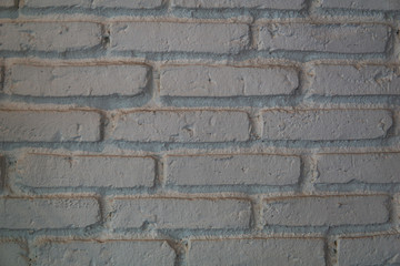 Close up of white bricks wall rough texture and uneven alignment.