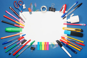 Fototapeta premium Stationery and blank paper on blue background. Education concept with copy space for your ideas. Flat lay style.