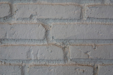 Close up of white bricks wall rough texture and uneven alignment.