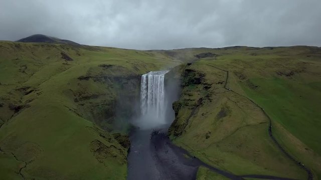 Aerial flight above Skogafoss, famous waterfall in southern Iceland. Most beautiful waterfall in Iceland during  spirng time. Green Iceland.