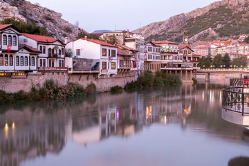 Fototapeta na wymiar Old Ottoman houses and clock tower view by the Yesilirmak River in Amasya City. Amasya is populer tourist destination in Turkey.