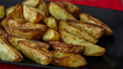 Seasoned rustic fries served on a black tray