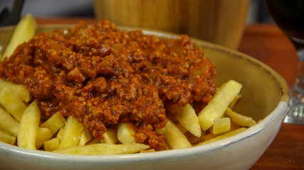 Crispy french fries with chilli on top close up