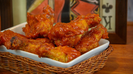 Buffalo wings greased in barbecue sauce in a tray