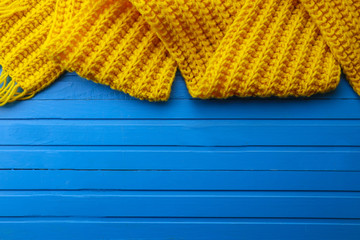 Frame made with yellow scarf on wooden background