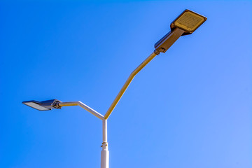 street lamps aligned with beautiful blue sky in background