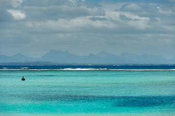 Fototapeta na wymiar A man takes profit of the paradise beach of Pointe des Canonniers, Indian Ocean, Mauritius island 