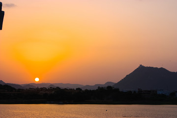 sunset view from the terrace of the lake palace hotel in Udaipur, India