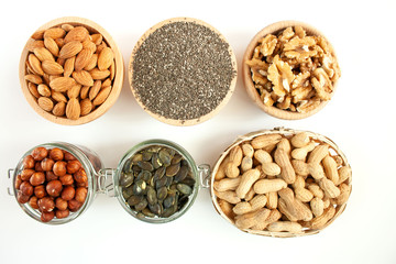 Nuts and seeds in bowls arranged on a white background