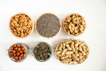 Nuts and seeds in bowls arranged on a white background