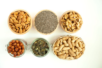 Nuts and seeds in bowls arranged on a white background