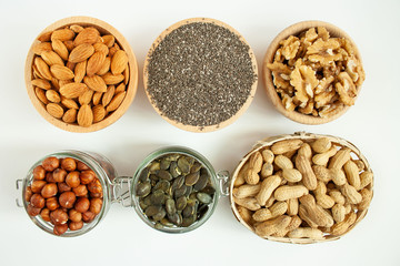 Orzechy i nasiona w miskach ustawionych na białym tle