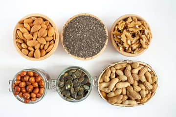 Nuts and seeds in bowls arranged on a white background