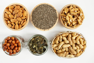 Nuts and seeds in bowls arranged on a white background