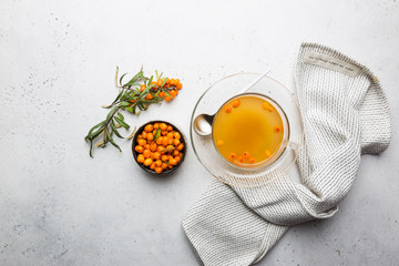 Tea with sea buckthorn on white stone background. top view