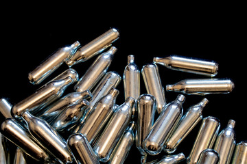 Nitrous Oxide Metal Bulb Canisters Recreational Drugs on Black Background