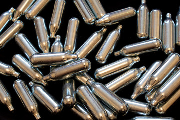 Nitrous Oxide Metal Bulb Canisters Recreational Drugs on Black Background