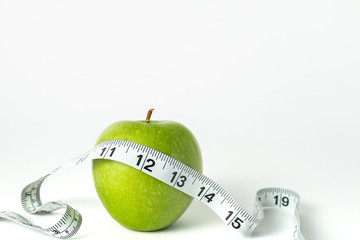 Green apple with measuring tape isolated on a white background, horizontal
