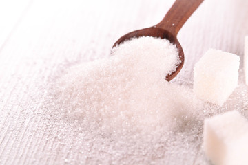 White cane sugar on a light wooden background