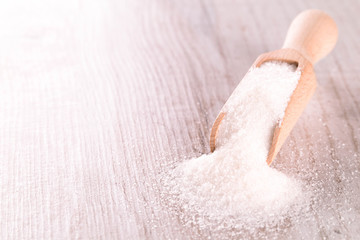 Fototapeta premium White cane sugar on a light wooden background