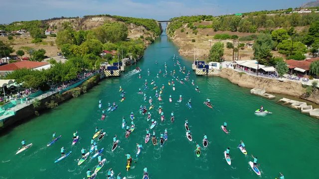 Aerial bird's eye view video taken by drone of stand up paddle surfers in annual SUP crossing competition in Corinth Canal, Greece